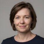 Портрет уверенного российского бизнесмена с дружелюбным взглядом на размытом нейтральном фоне в студии